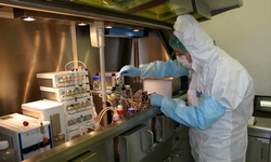 In einem Reinraum stellt ein Mitarbeiter radioaktive Wirkstoffe her.